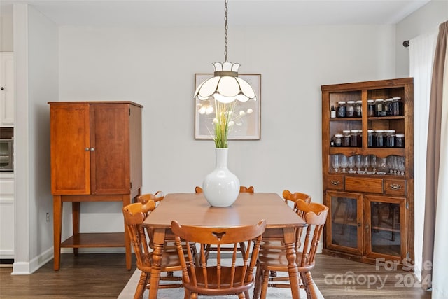 dining space with dark hardwood / wood-style flooring and a chandelier