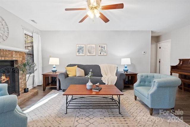 living room with ceiling fan, a fireplace, and light wood-type flooring