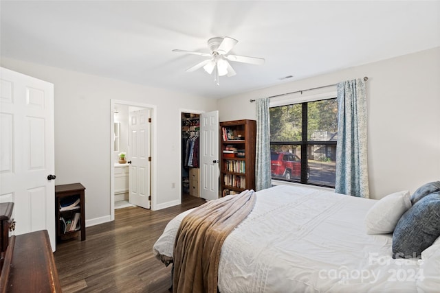 bedroom with a walk in closet, ensuite bath, ceiling fan, dark wood-type flooring, and a closet