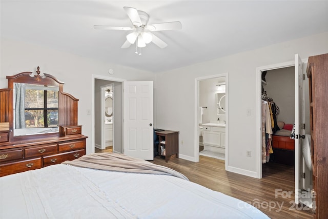 bedroom with dark wood-type flooring, ensuite bath, ceiling fan, a spacious closet, and a closet