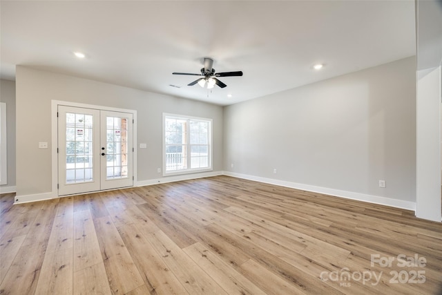 empty room featuring light hardwood / wood-style flooring, ceiling fan, and french doors