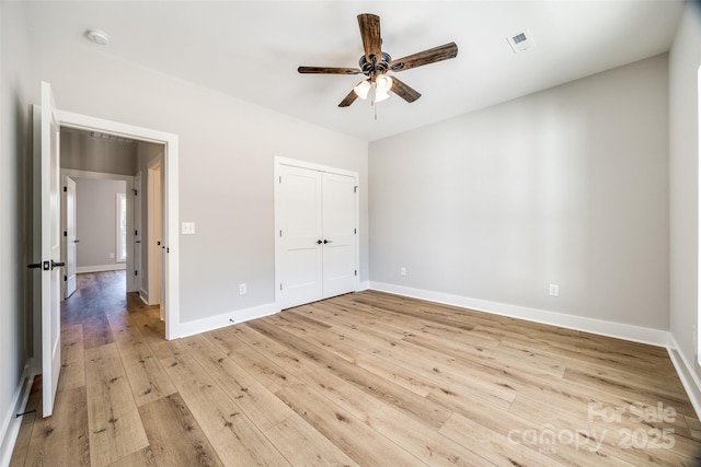 unfurnished bedroom with ceiling fan, a closet, and light hardwood / wood-style flooring