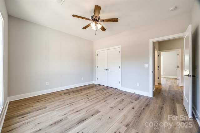 unfurnished bedroom with light hardwood / wood-style flooring, a closet, and ceiling fan