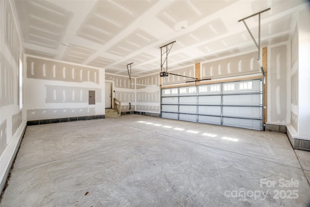 garage with a garage door opener and electric panel