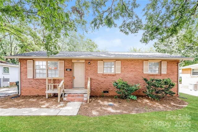 ranch-style house with central AC unit and a front yard