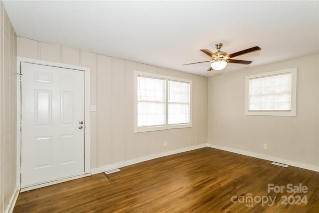 unfurnished room with a wealth of natural light, ceiling fan, and dark hardwood / wood-style floors