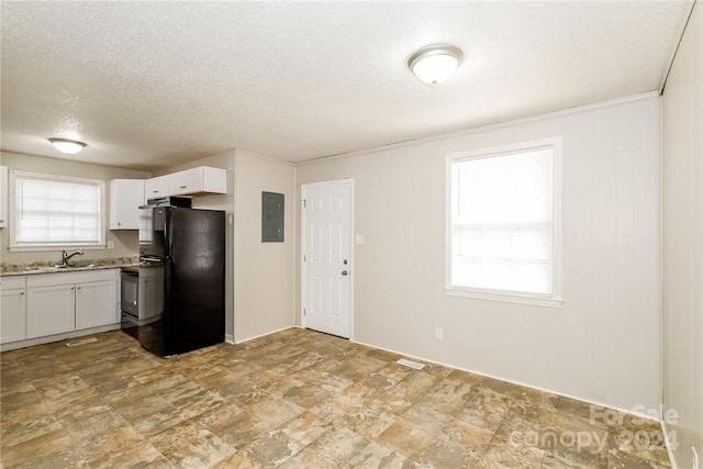 kitchen with electric panel, black fridge, white cabinets, and a textured ceiling