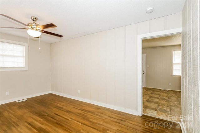 empty room with ceiling fan and hardwood / wood-style flooring