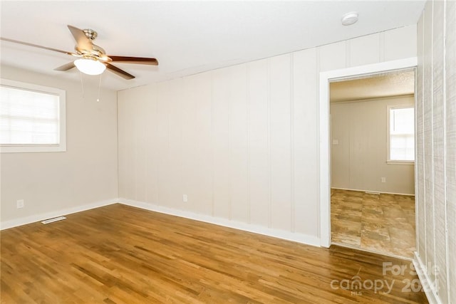 spare room with hardwood / wood-style floors and ceiling fan