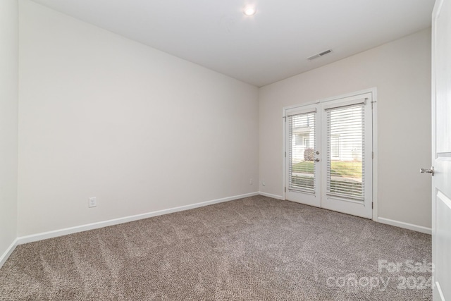 empty room with french doors and carpet floors