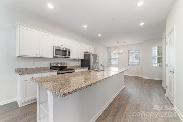 kitchen with appliances with stainless steel finishes, sink, a center island with sink, white cabinets, and light hardwood / wood-style floors