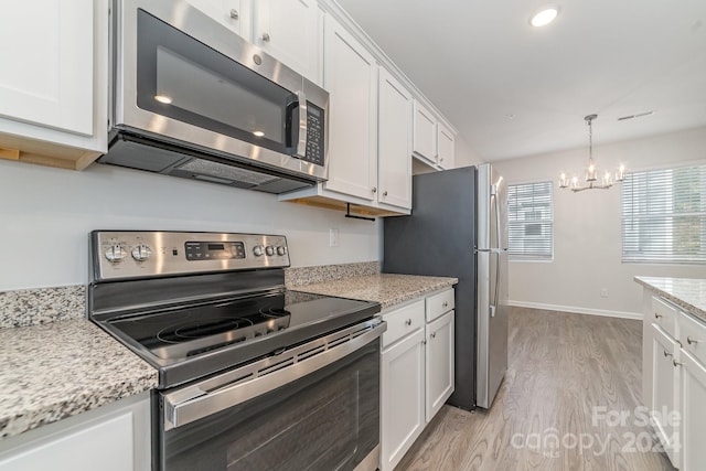 kitchen with white cabinetry, an inviting chandelier, light hardwood / wood-style floors, and appliances with stainless steel finishes