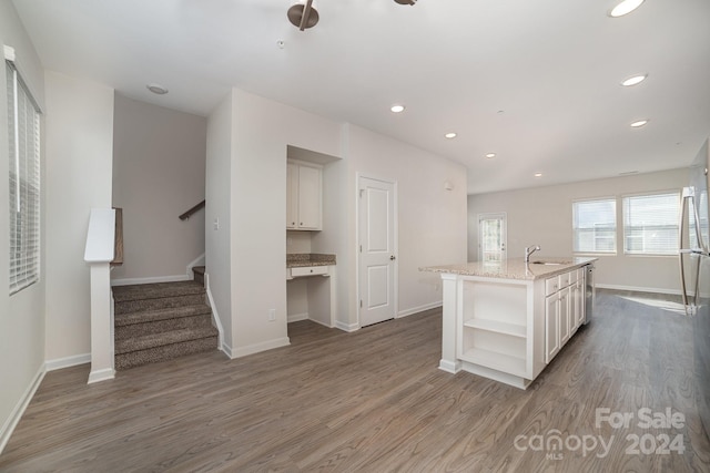 kitchen with dark hardwood / wood-style flooring, sink, and an island with sink