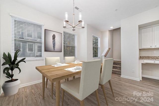 dining room featuring an inviting chandelier, light hardwood / wood-style flooring, and a healthy amount of sunlight