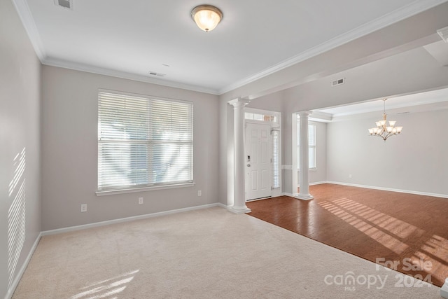 interior space with decorative columns, crown molding, a chandelier, and wood-type flooring