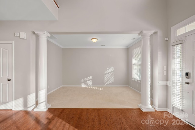 entrance foyer featuring crown molding, plenty of natural light, and wood-type flooring