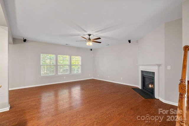 unfurnished living room with dark hardwood / wood-style flooring and ceiling fan