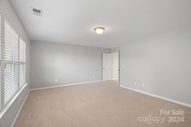 unfurnished room featuring light carpet