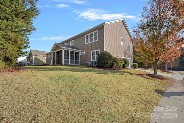 exterior space featuring a sunroom, central AC unit, and a yard