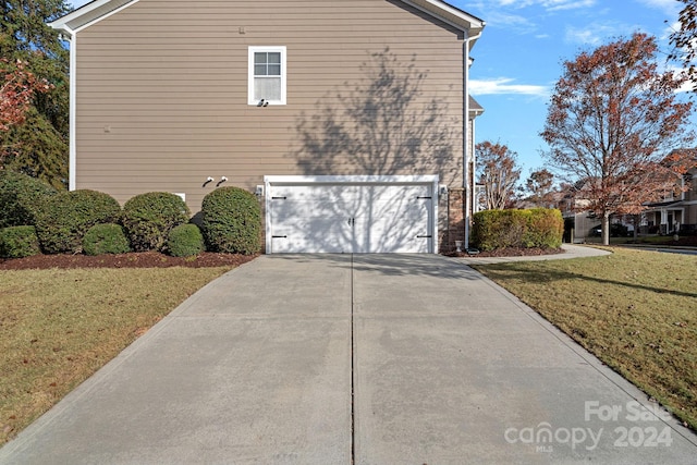 view of side of home with a yard and a garage