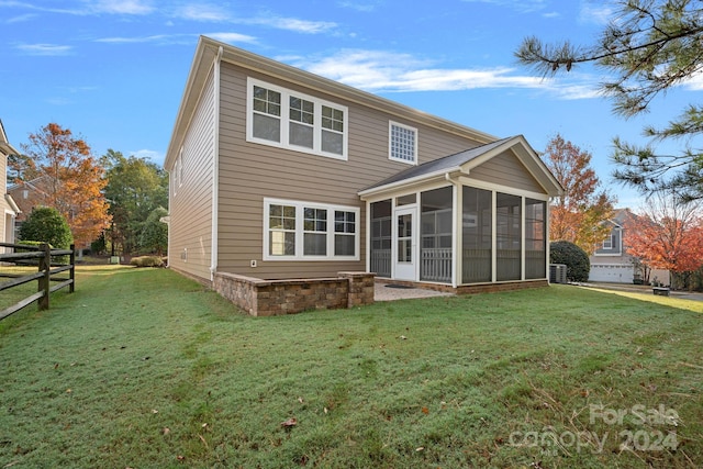 rear view of house with a lawn and a sunroom