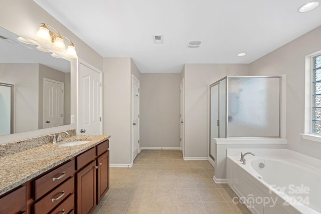 bathroom featuring tile patterned flooring, vanity, and shower with separate bathtub