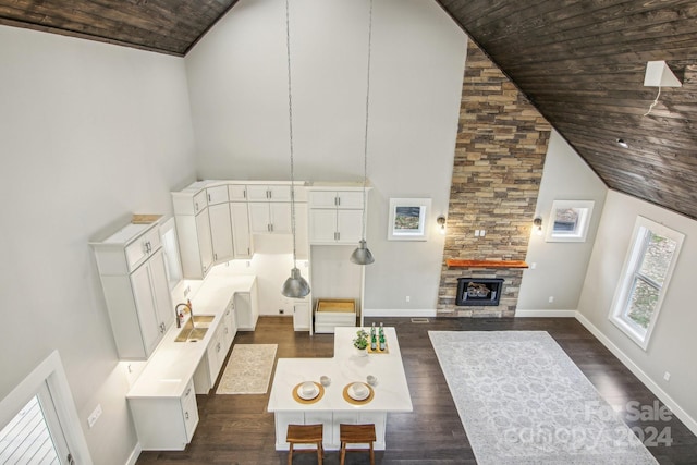 living room featuring dark hardwood / wood-style flooring, wooden ceiling, a fireplace, and high vaulted ceiling