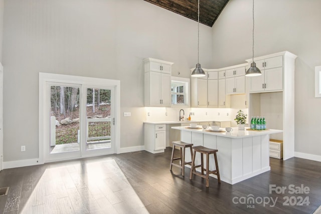 kitchen with dark hardwood / wood-style flooring, a center island, white cabinets, and hanging light fixtures