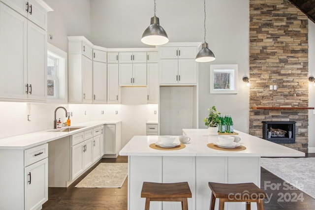 kitchen with white cabinets, a kitchen island, and hanging light fixtures