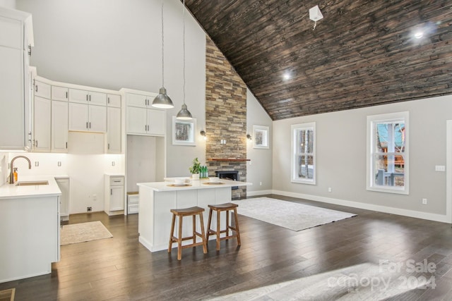 kitchen with white cabinetry, sink, high vaulted ceiling, pendant lighting, and a kitchen island