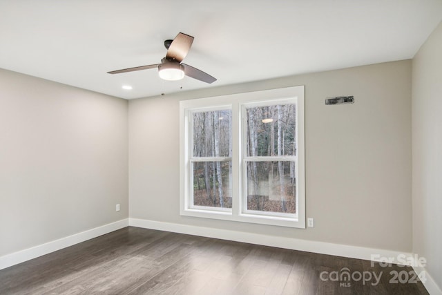 unfurnished room featuring ceiling fan and dark wood-type flooring