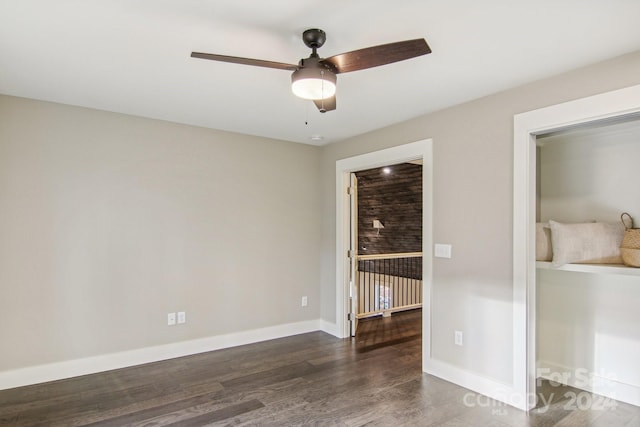 unfurnished room with ceiling fan and dark hardwood / wood-style flooring