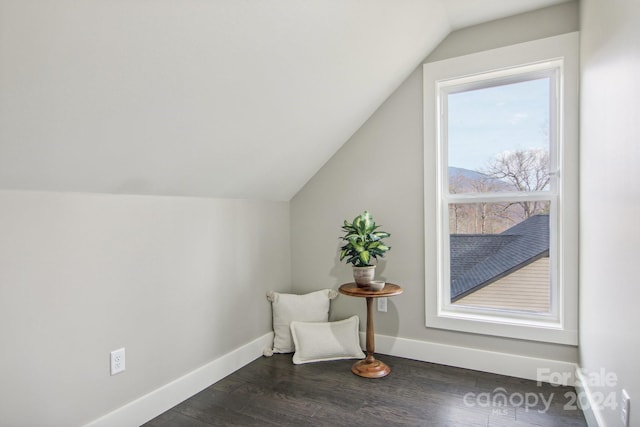 sitting room with lofted ceiling and dark wood-type flooring