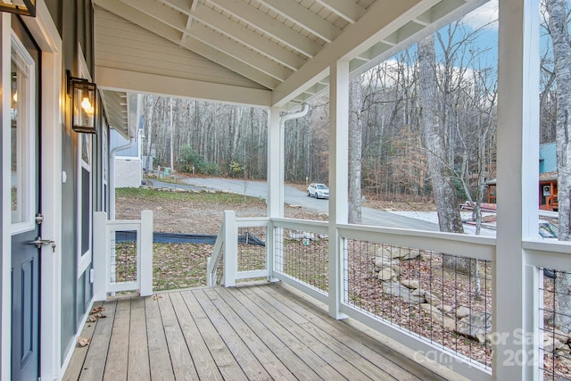 unfurnished sunroom featuring lofted ceiling with beams