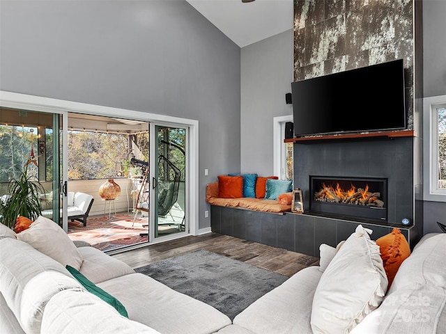 living room featuring hardwood / wood-style flooring, a fireplace, and high vaulted ceiling