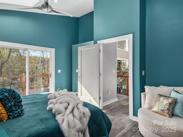 bedroom featuring hardwood / wood-style flooring and a towering ceiling