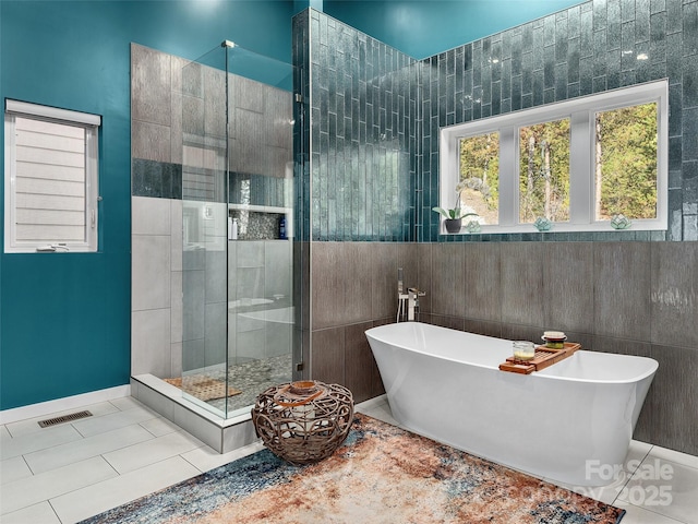 bathroom featuring plus walk in shower and tile patterned flooring