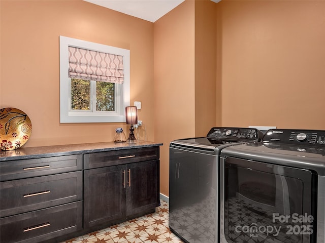 laundry room with cabinets and washing machine and clothes dryer