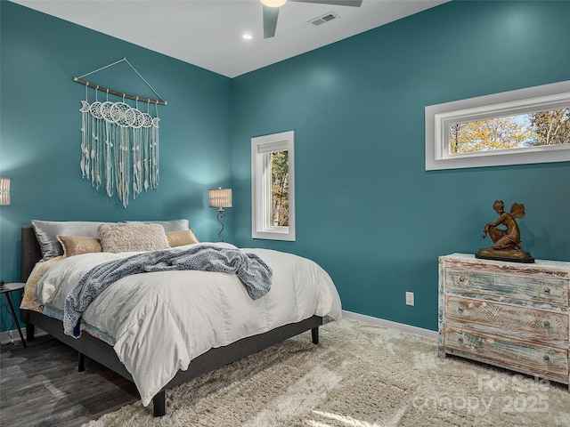 carpeted bedroom featuring multiple windows and ceiling fan