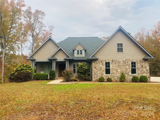 view of front of house featuring covered porch and a front lawn