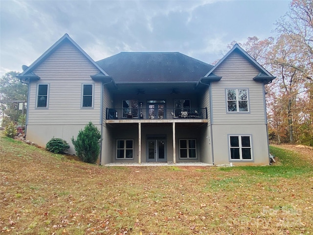 rear view of house with a lawn, ceiling fan, a balcony, and a deck