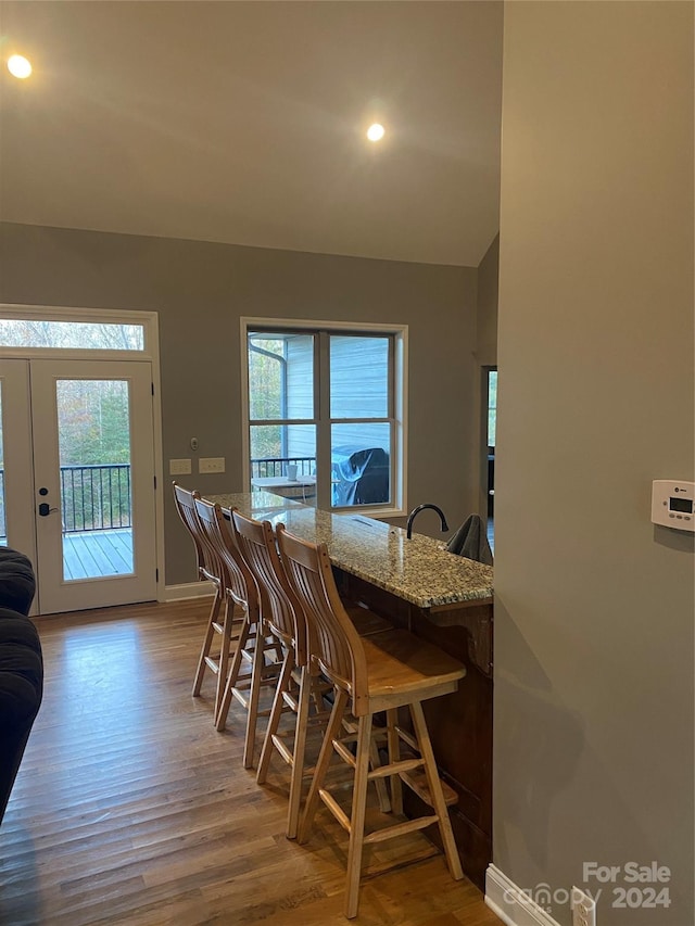 dining space with a healthy amount of sunlight, french doors, and light hardwood / wood-style flooring