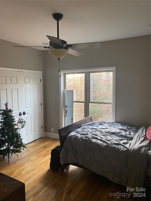 bedroom with ceiling fan, a closet, and light wood-type flooring