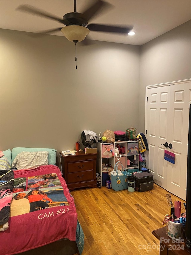 bedroom featuring ceiling fan, a closet, and light hardwood / wood-style flooring