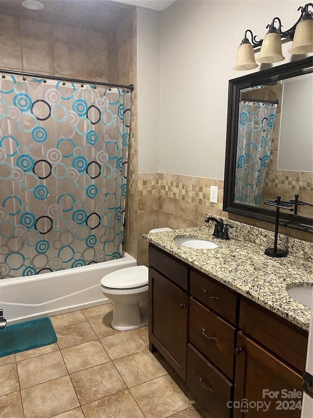 full bathroom featuring vanity, tile patterned floors, shower / bath combination with curtain, toilet, and tile walls