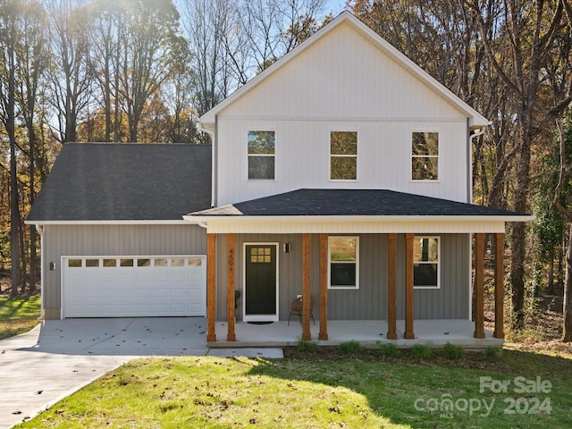 view of front of house with a porch, a garage, and a front lawn