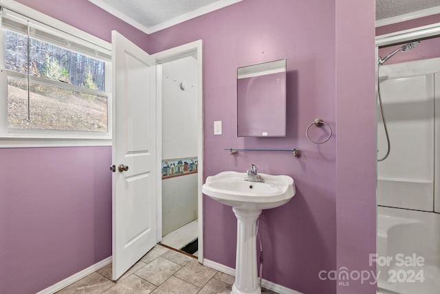 bathroom with ornamental molding, a textured ceiling, sink, a shower, and tile patterned flooring