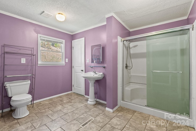 bathroom featuring toilet, a shower with door, a textured ceiling, and ornamental molding