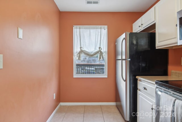 kitchen featuring white cabinets, appliances with stainless steel finishes, and light tile patterned flooring