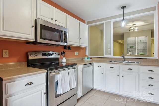 kitchen featuring white cabinetry, sink, pendant lighting, light tile patterned flooring, and appliances with stainless steel finishes